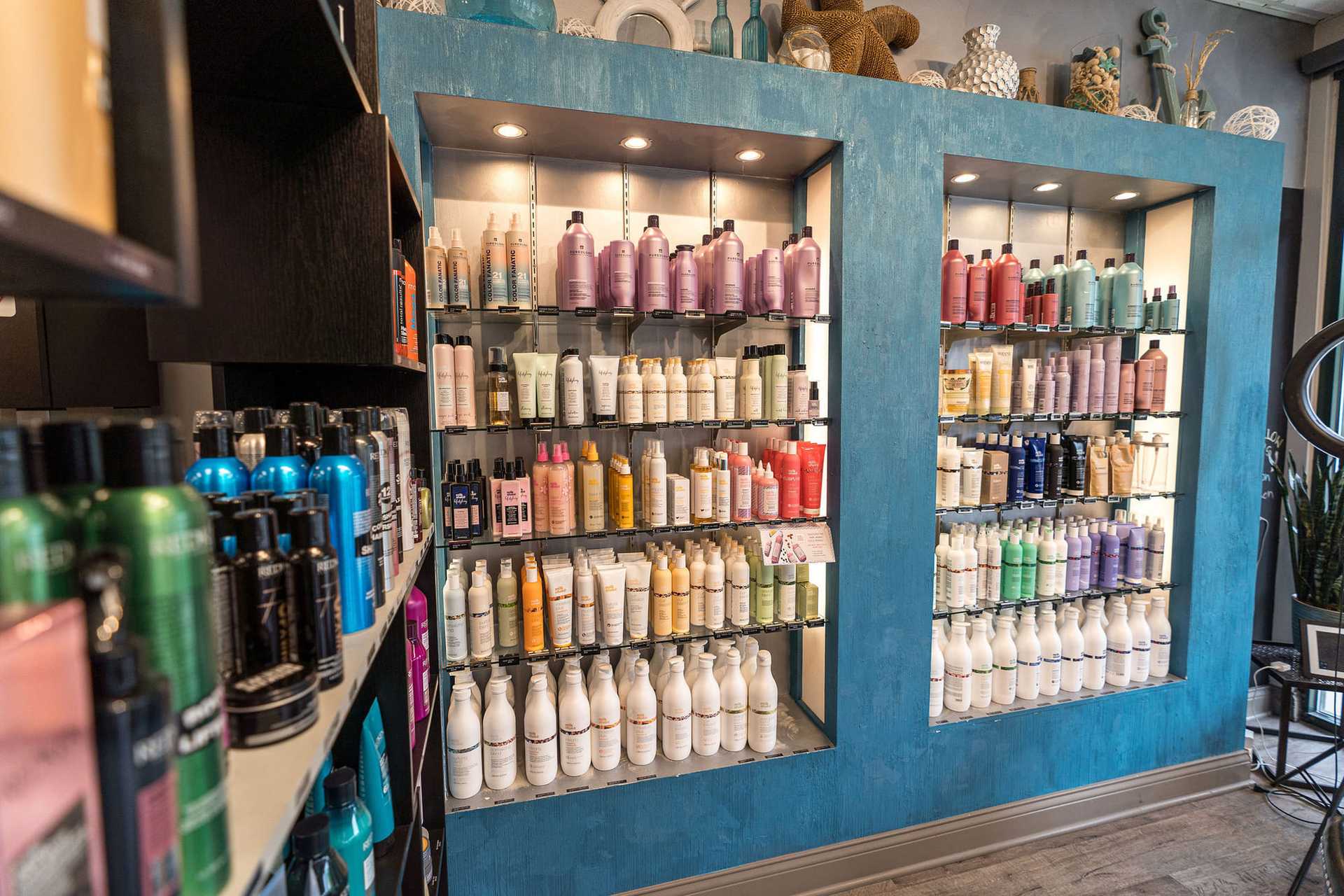 Shelves of assorted haircare products in a well-lit salon or store with colorful bottles and tubes.
